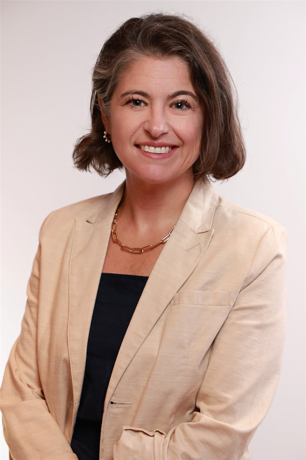 Julie Peller in a cream blazer against a neutral background